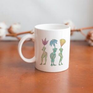 white mug with beautiful illustration of 3 flowers with the bodies of human women.